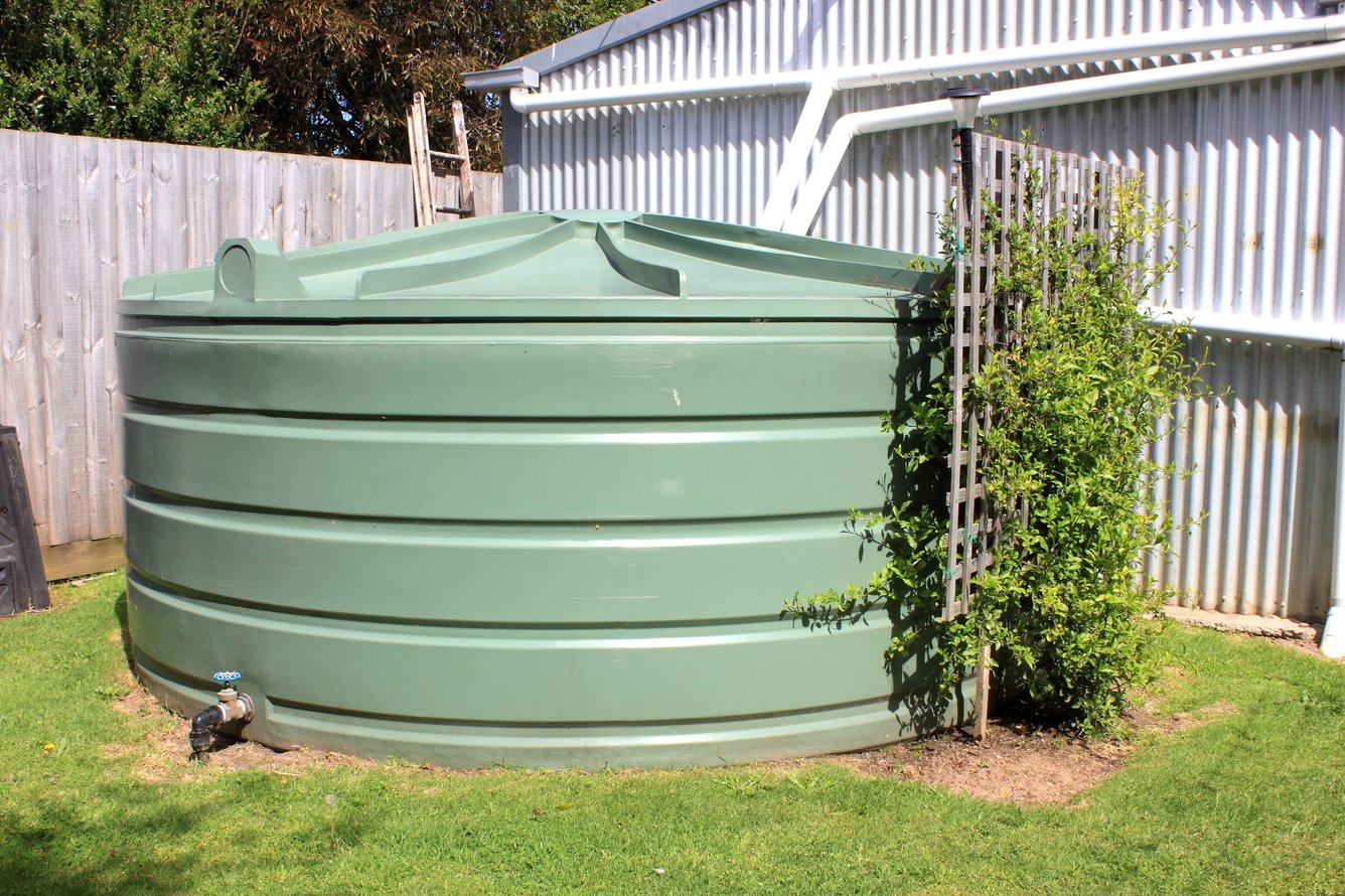 Large eco- friendly water storage tank in suburban backyard