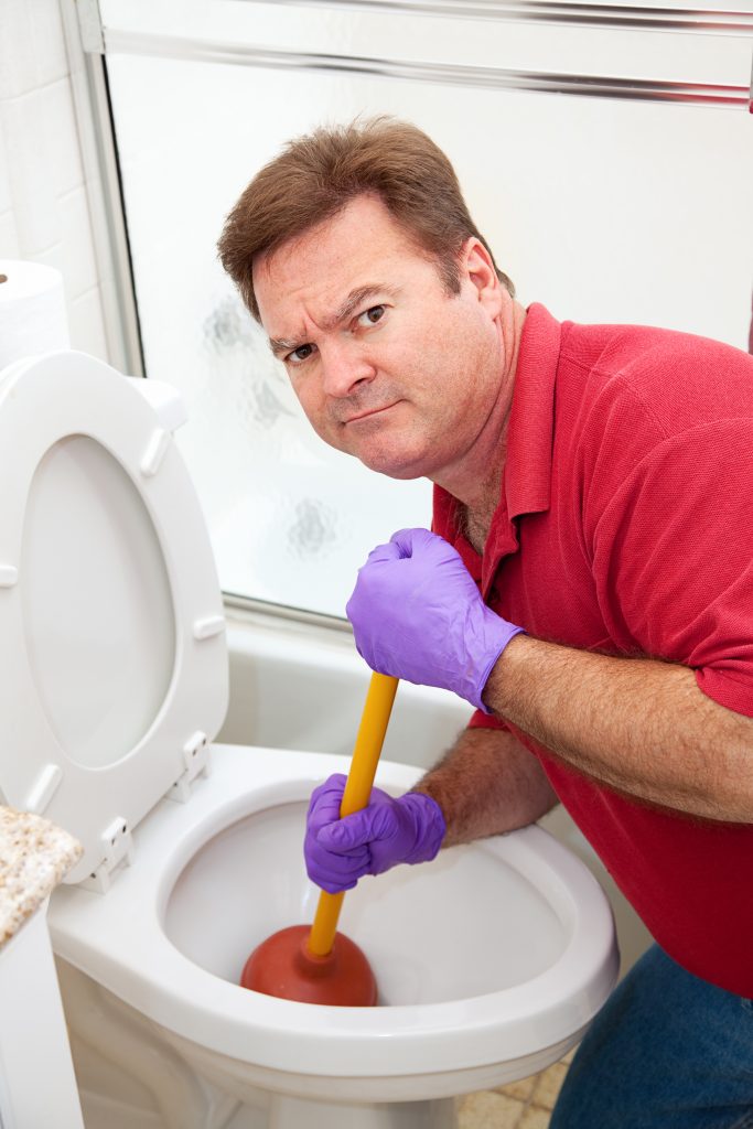 a not-so-happy man trying to unclog his toilet