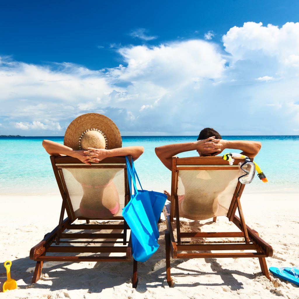 couple having a tan on their beach holiday