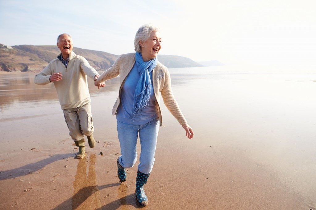 two happy old couple in the beach