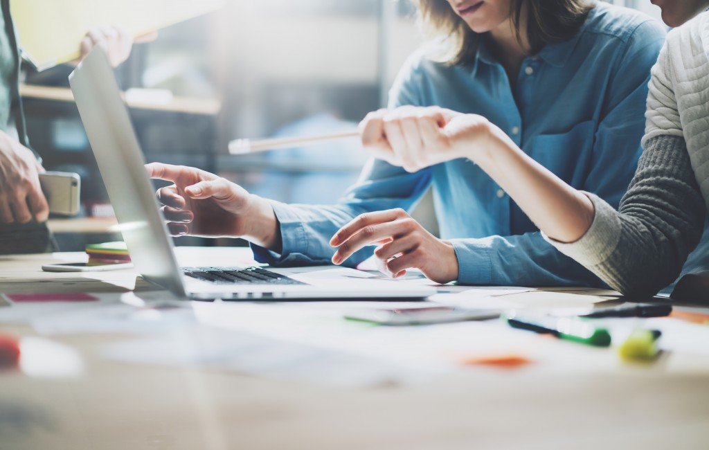 two people working in front of a laptop