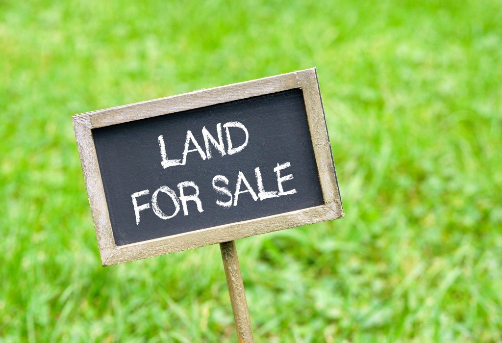 Land for sale - chalkboard with text on green grass background