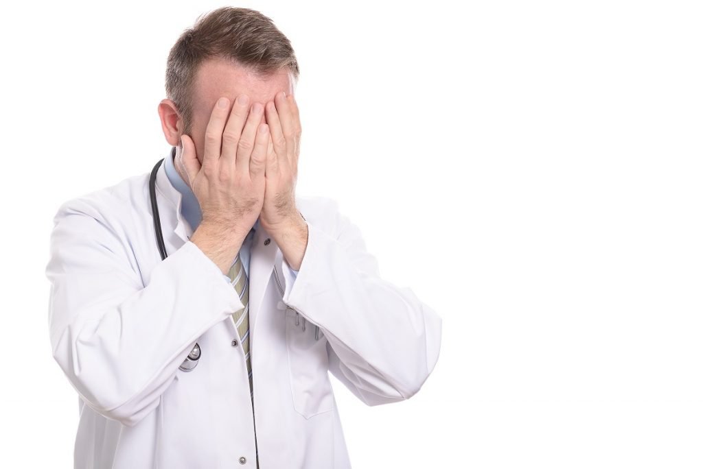 Frustrated doctor covering his face