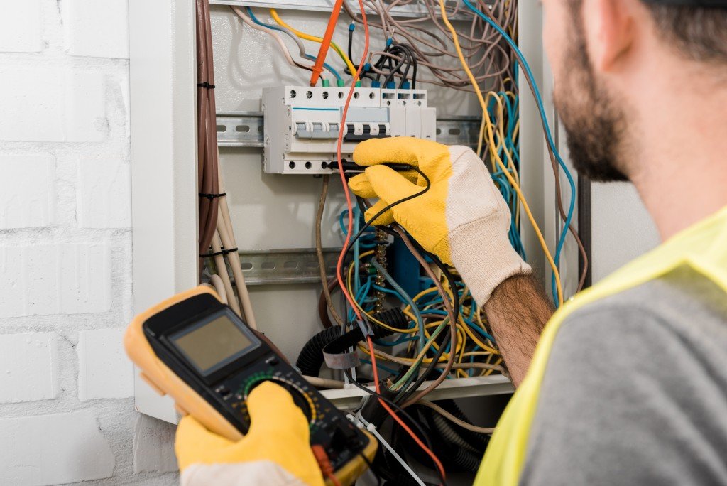 man checking the wires in the circuit box
