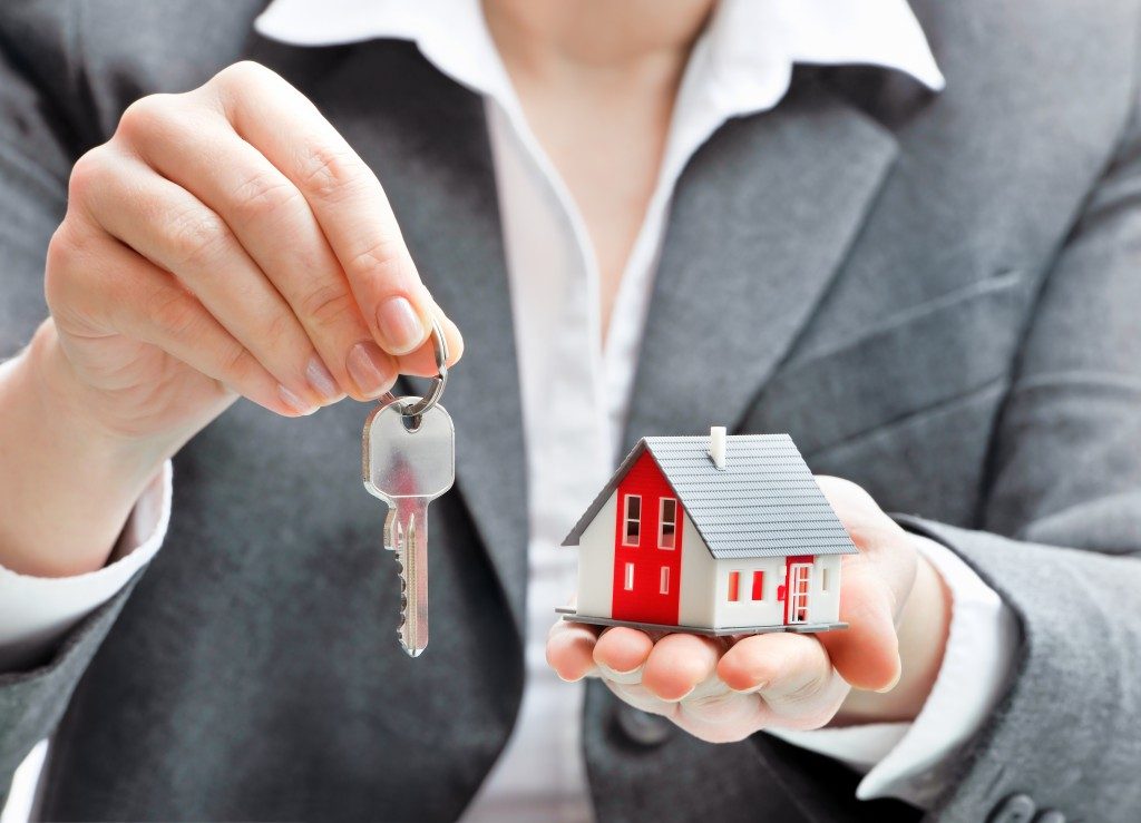 woman holding keys and house model