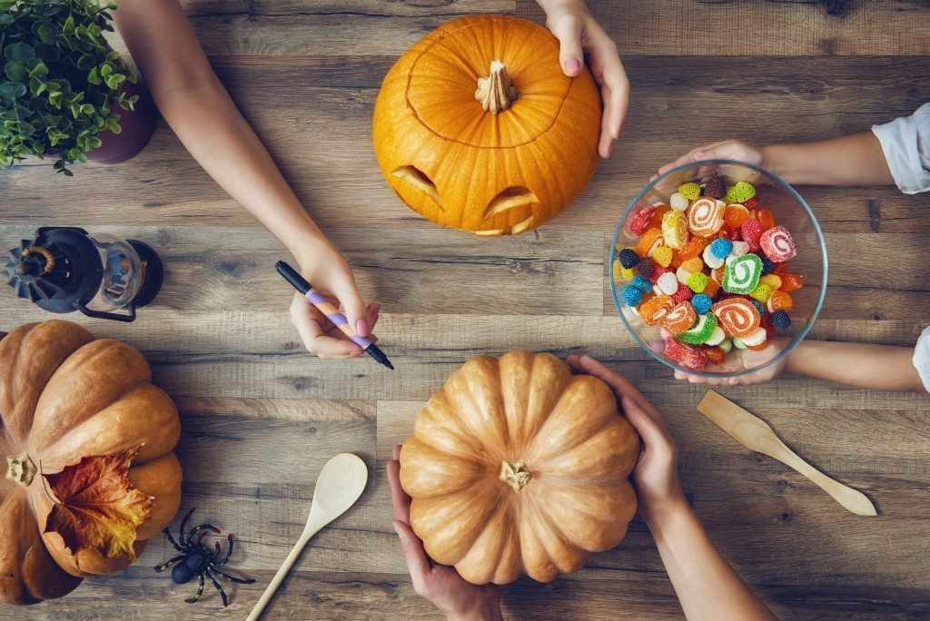 people carving pumpkins for halloween