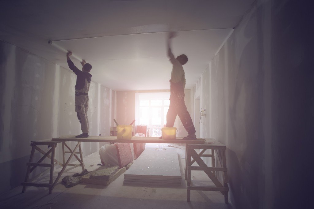 Workers installing drywall