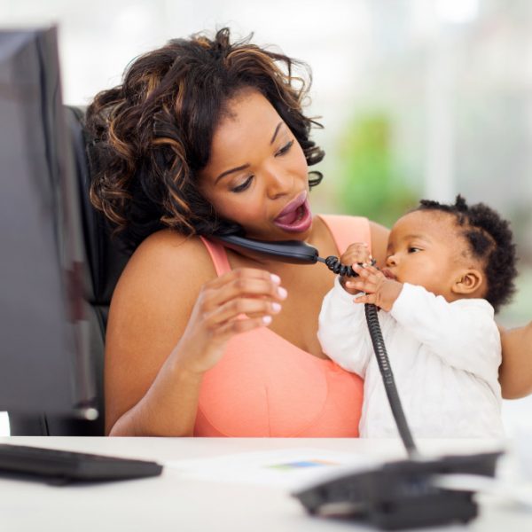 woman taking care of child while talking on the phone