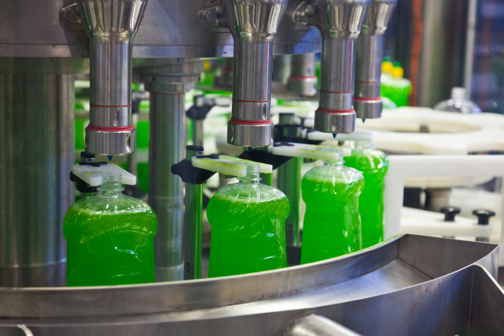 production plant with green chemicals being transferred to a container by a machine