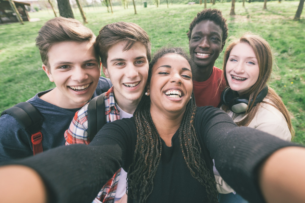 Diverse group of teenagers taking a selfie in a park