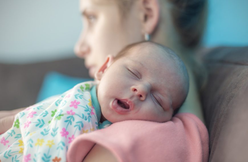 newborn baby girl carried by her mother