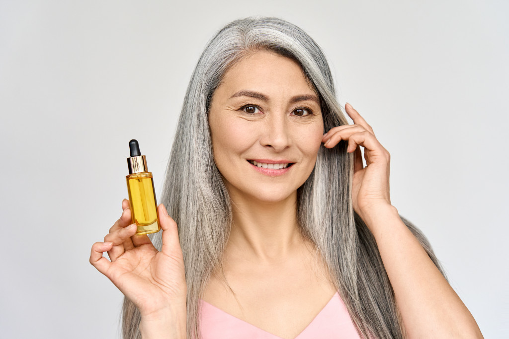 An aging woman using hair products