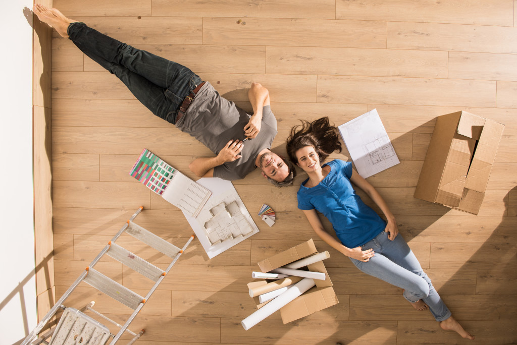 young couple lying don on the floor thinking about home improvement